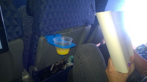 plastic device holds cup and tablet on placne